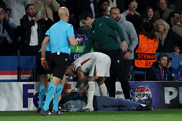 A ball kid lies on the floor after being pushed over by Pedro Neto of Chelsea (not pictured) as they are checked on by Enzo Fernandez of Chelsea during the UEFA Champions League 2025/26 Round of 16 First Leg match between Paris Saint-Germain FC and Chelsea FC at Parc des Princes on March 11, 2026 in Paris, France. (Photo by Justin Setterfield/Getty Images)