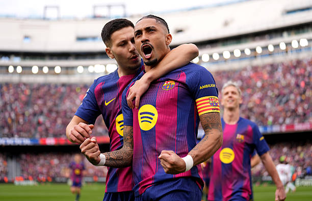BARCELONA, SPAIN - MARCH 15: Raphinha of FC Barcelona celebrates scoring his team's first goal with teammate Roony Bardghji during the LaLiga EA Sports match between FC Barcelona and Sevilla FC at Spotify Camp Nou on March 15, 2026 in Barcelona, Spain. (Photo by Alex Caparros/Getty Images)